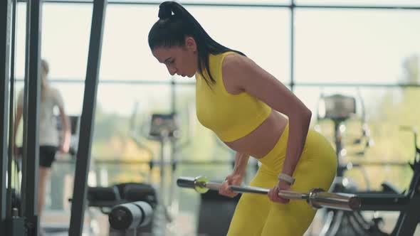 Hispanic Woman Performing Barbell Bent Over Row