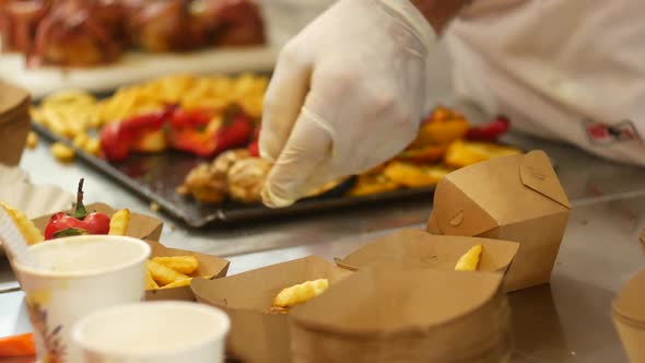 Cook Serves French Fries And Baked Vegetables