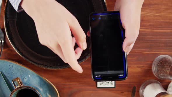 Scanning QR Code in Restaurant Top View