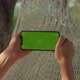 Young Women Rests in Hammock Looking Into Sideways Phone with Green Screen - VideoHive Item for Sale
