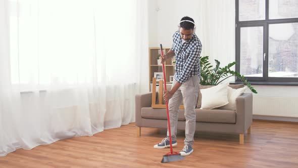 Man in Headphones with Broom Cleaning at Home 114