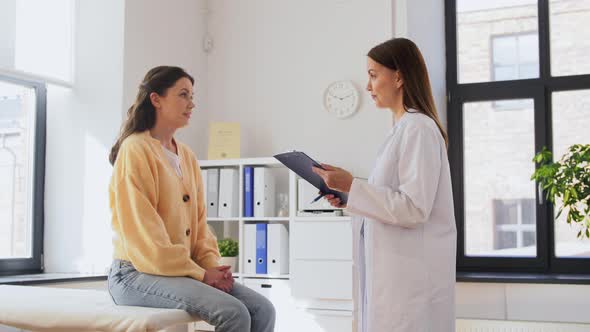 Doctor with Clipboard and Woman at Hospital