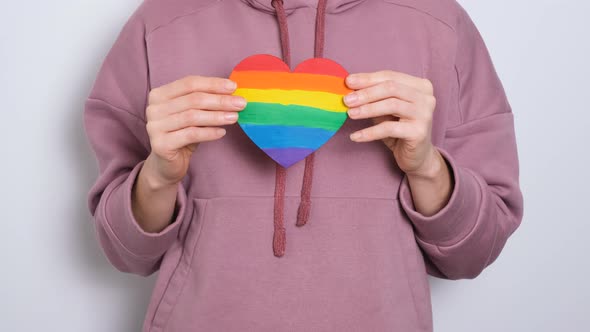 Woman or Girl in Purple Hoodie Holding Heat Painted in Colors of Gay Pride Flag Colorful Symbol of