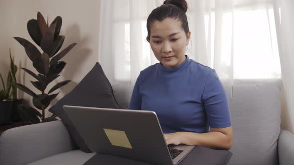 Asian business woman happily use laptops to work from home online