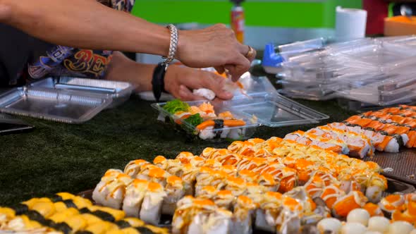 Seller Man Hand Choosing and Put Fresh Sushi in Plastic Bag From Night Market