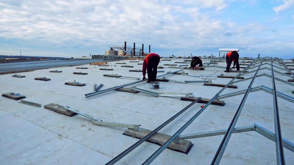 Workers install metal base for solar panels