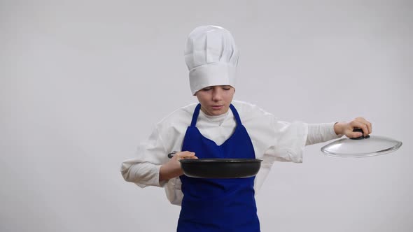 Positive Confident Little Cook Opening Frying Pan Smelling Tasty Food Looking at Camera with Proud