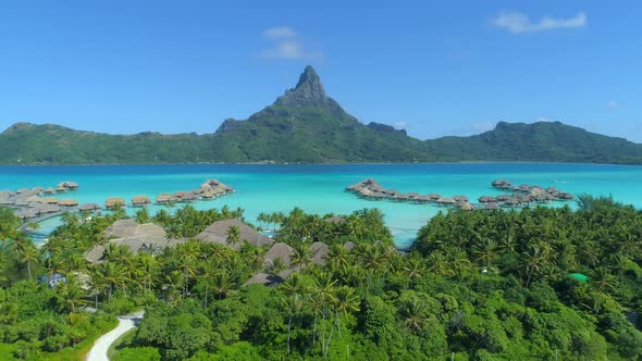 Aerial drone view of a luxury resort and overwater bungalows in Bora Bora tropical island.