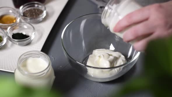 Putting natural yogurt into the glass bowl