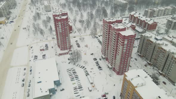 Highrise Residential Buildings and a City Road are Covered with White Snow