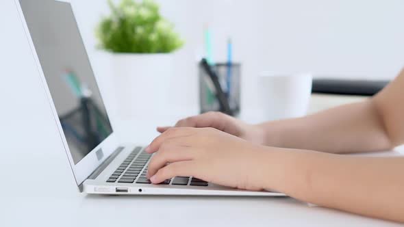 Closeup freelance woman working and typing on laptop computer at desk office.