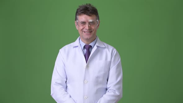 Mature Handsome Man Doctor Against Green Background