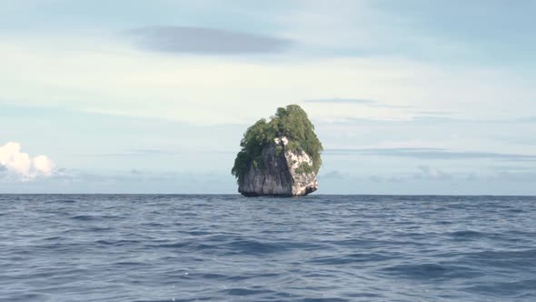 Sailing by a very small limestone island in El Nido, Palawan, the Philippines in ultra slow motion