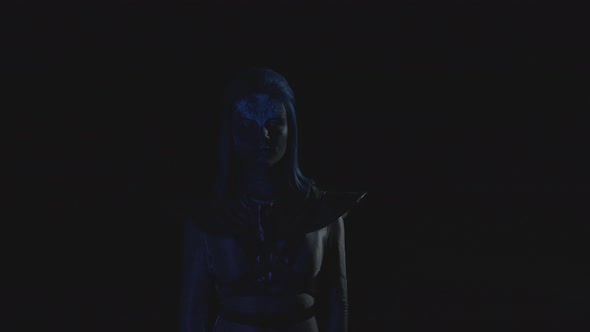 Woman with a Glowing Blue Face Looks at the Camera When the Light Blinks 