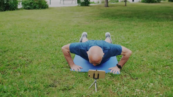 Eldery Grandpa or Mature Senior Man Makes Push Up with Help of His Doctor Online on Cellphone