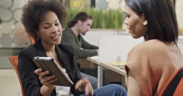 Businesswomen Discussing Data on Tablet