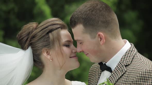 Newlyweds. Caucasian Groom with Bride Kissing in Park. Wedding Couple. Man and Woman in Love