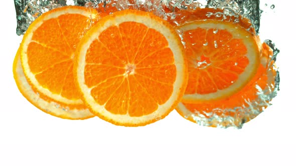 Super Slow Motion Shot of Falling Orange Slices into Water at 1000fps.