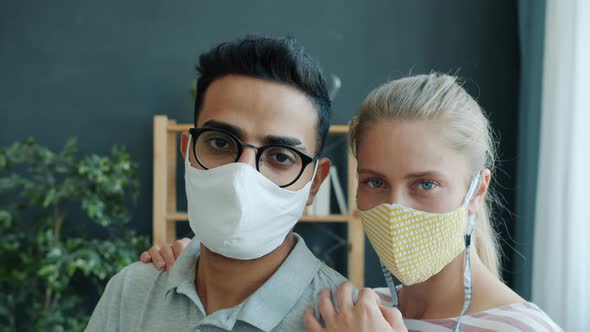 Slow Motion Portrait of Middle Eastern Man and Caucasian Woman in Medical Masks Indoors