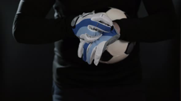 Close Up Goalkeeper Holding Soccer Ball in the Stadium Studio Football Player Hands Professional