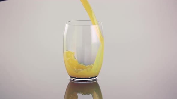 Orange juice pour into a glass in slow motion
