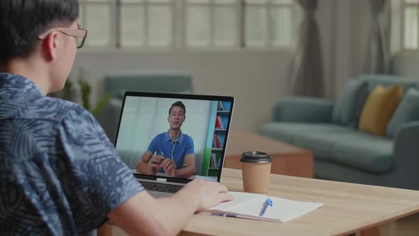 Man Waving Hand During Video Call With Man On Laptop Computer 