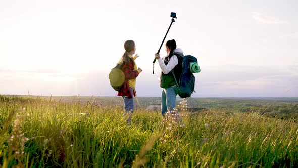Mom and Daughter in Nature Shoot Video Blog on Camera a Selfie Stick About Tourist Trip on Mountain