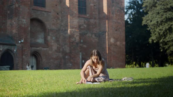 Woman reading a book near the ancient building
