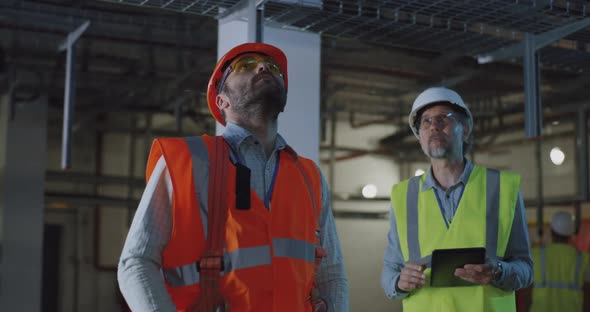 Engineer Showing Workshop To Inspector Using Tablet