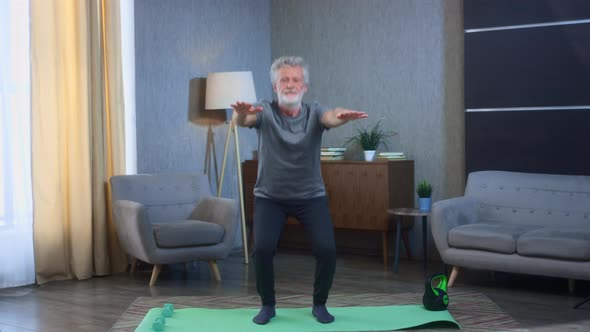 Portrait of a Grayhaired Senior Man with a Beard Squats