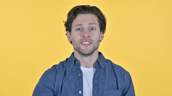 Young Man Celebrating Success, Winning on Yellow Background