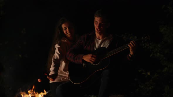 Roasting marshmallows and playing guitar