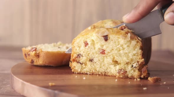 Cutting Bakery Fruit Cake with Knife on Chopping Board