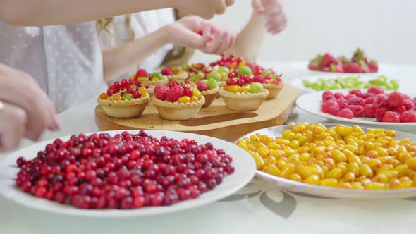 In the Kitchen Concept The Family Decorates the Pie and Muffins with a Berry