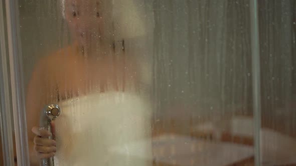 Mixed Race Lady in White Towels Walks Into Sauna and Sits