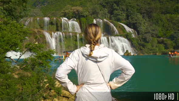 Raising Above a Woman Looking at a Waterfall