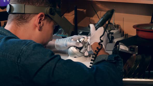 Jeweller Goldsmith Uses Tools While Working with a Golden Ring