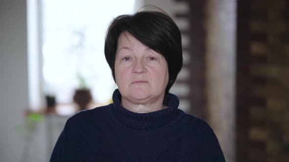 Portrait of an Elderly Woman with Wrinkles on Her Face Looking at the Camera