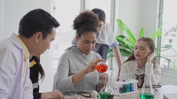 Diversity group of students in science class doing chemical experiment