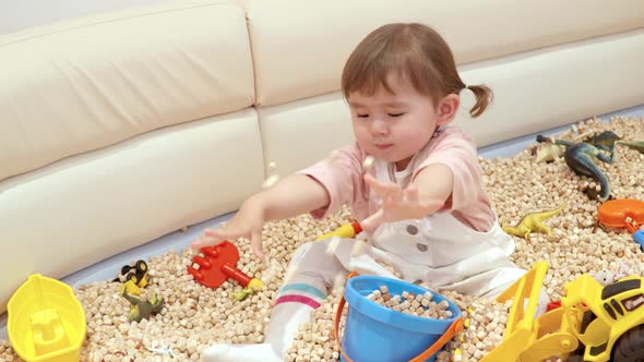 Portrait Of A Two Years Old Toddler Playing Toy Bucket In A Cafe. Close Up