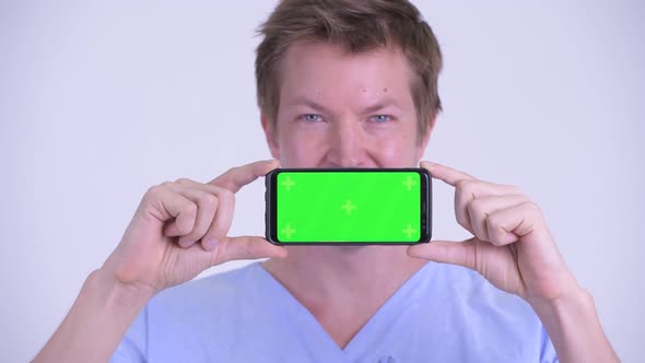 Face of Happy Young Man Patient Thinking While Showing Phone
