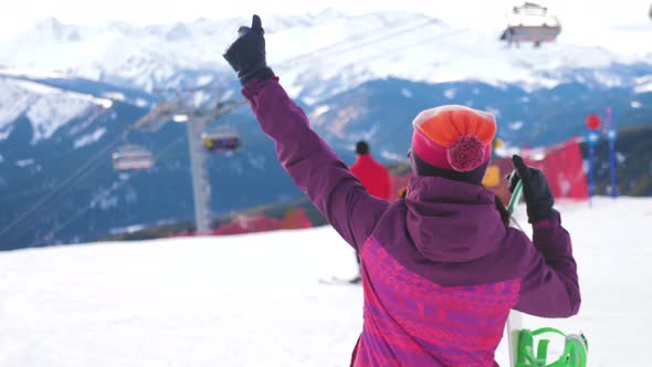 A Young Woman on a Snowboard on Top Mountain on a Ski Track