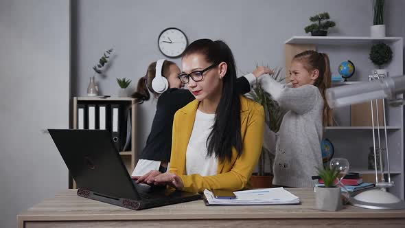  Businesswoman in Glasses Massaging the Temples Becouse Her Noisy Playful Teen Daughters