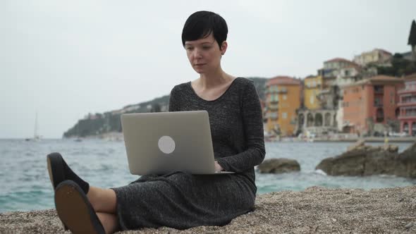 Woman On The Seaside Working On The Computer