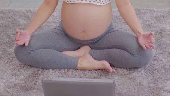 Top view Pregnant woman practice yoga online class lotus pose to meditation smile with big belly