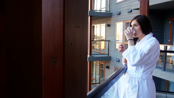 Woman having a cup of coffee in balcony