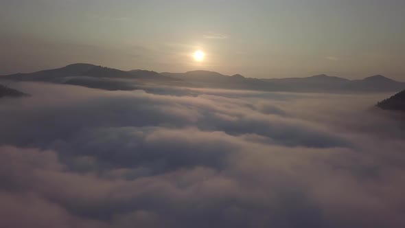 Aerial drone view of foggy sunrise over clouds hills and mountains at morning Carpathian mountains