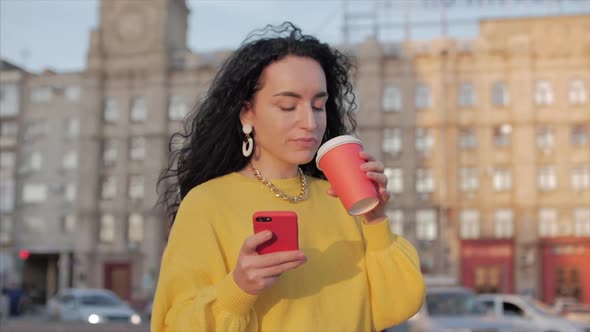 Woman Young Muslim Walking in the City Center, Using Smartphone and Drinking Coffee. Concept