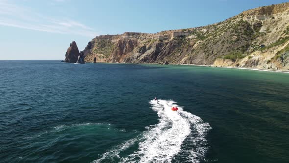 Happy People Swim on Air Mattress Behind a High Speed Water Bike