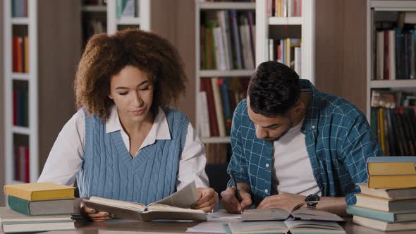 Students Studying in Library Doing Homework Preparing for Exam Young Girl Reads Textbook Searches